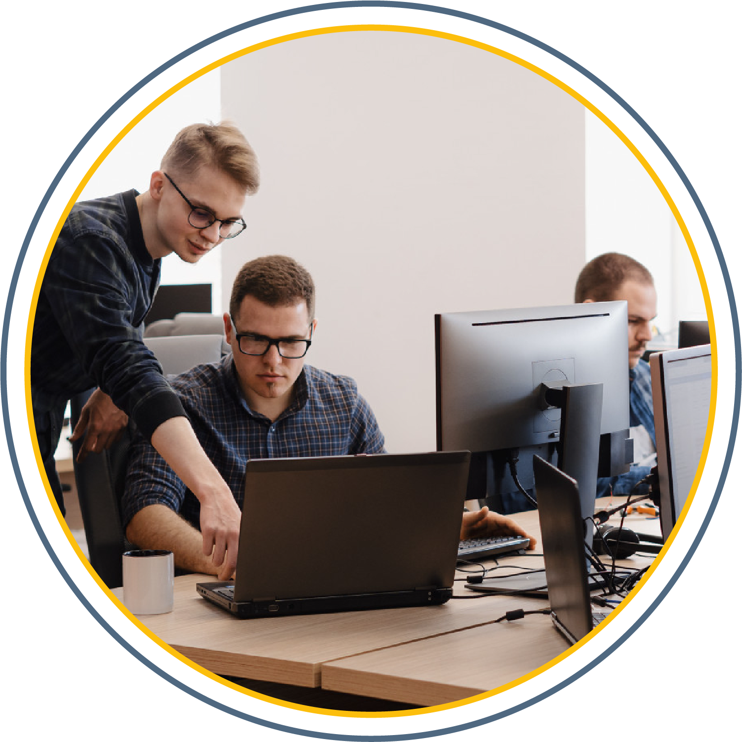 Employees working gathered around a laptop